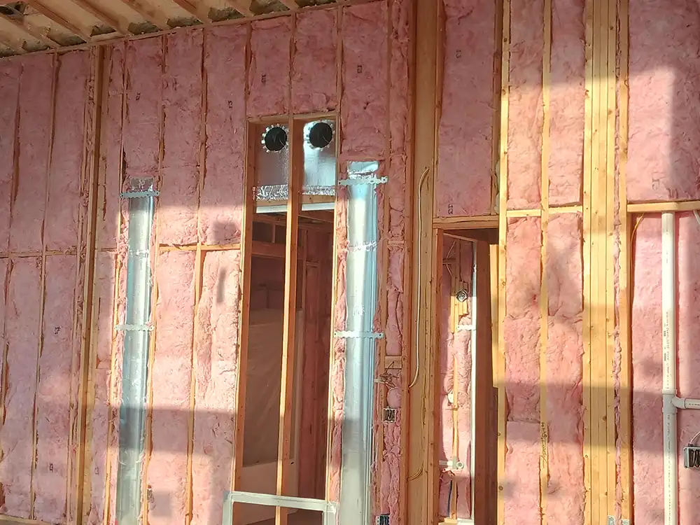 Professional fiberglass batt insulation installation in a framed building by True North Insulation